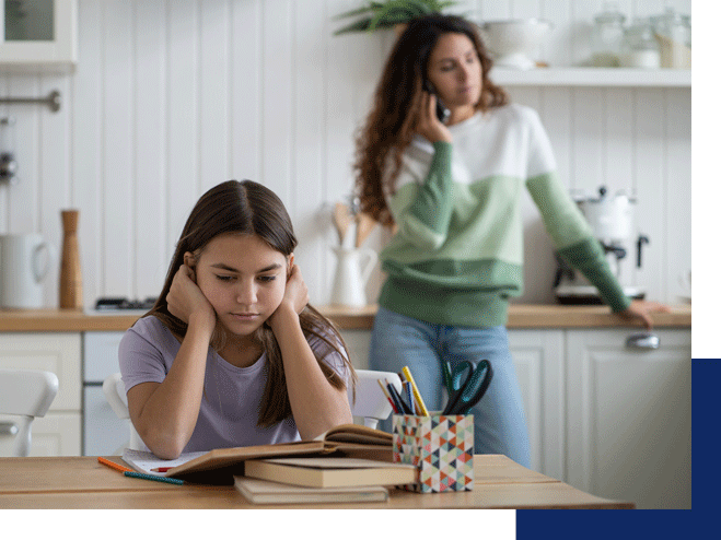 A mom is on the phone while a daughter waits to do her homework. ADHD counseling in Tustin, CA can help your child learn in a way that works for them.