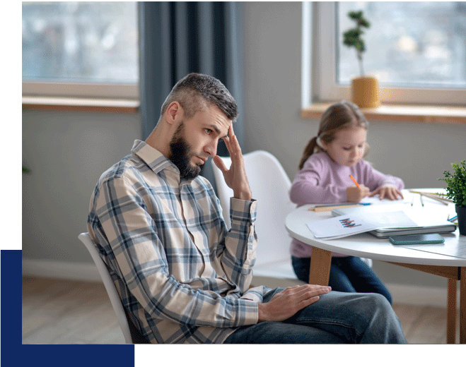 A dad holds his head looking tired. ADHD counseling in Tustin, CA can help you reclaim harmony in your home.
