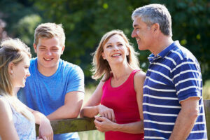 A smiling family in a backyard. This image depicts the joy that comes when learning to parent ADHD children successfully.