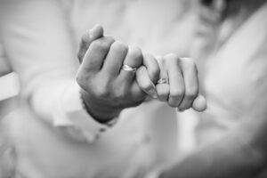 hands of a couple intertwined, showing their wedding rings. here are the steps in restoring trust after infidelity